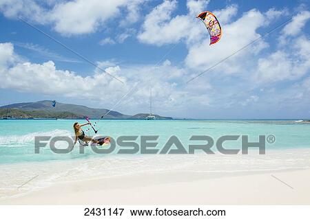 Stock Photo - Professional kiteboarder Susi Mai kitesurfing over the crystal blue waters; Necker Island, British Virgin Islands. Fotosearch