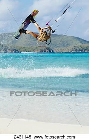 Stock Photo - Professional kiteboarder Susi Mai kitesurfing over the crystal blue waters; Necker Island, British Virgin Islands. Fotosearch