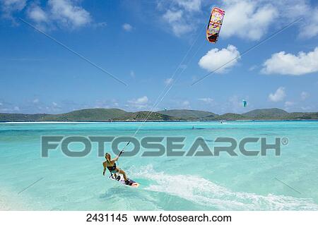Stock Photography - Professional kiteboarder Susi Mai kitesurfing over the crystal blue waters; Necker Island, British Virgin Islands. Fotosearch