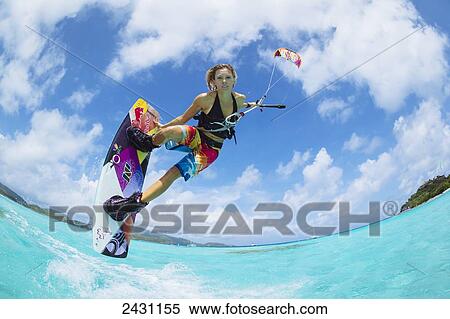 Stock Photography - Professional kiteboarder Susi Mai kitesurfing over the crystal blue waters; Necker Island, British Virgin Islands. Fotosearch