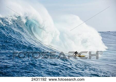 Stock Image - Professional surfer Kai Lenny paddling into large waves at the infamous big wave spot know as Jaws or Peahi; Maui, Hawaii, United States of America. Fotosearch
