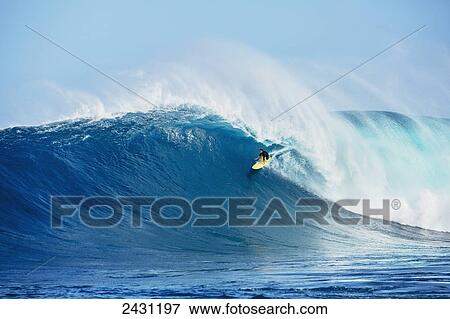 Stock Photo - Professional surfer Nakoa Decoite paddling into large waves at the infamous big wave spot know as Jaws or Peahi; Maui, Hawaii, United States of America. Fotosearch