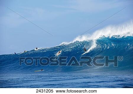 Stock Photography - Professional surfers paddling into large waves at the infamous big wave spot know as Jaws or Peahi; Maui, Hawaii, United States of America. Fotosearch