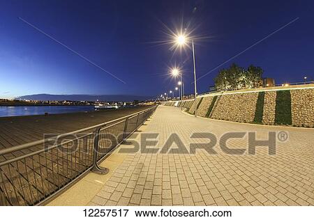 Stock Photo - Promenade along the River Tyne light by lights at dusk; South Shields, Tyne and Wear, England. Fotosearch
