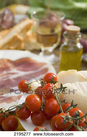 Stock Photo - Prosciutto Ham, Cheese, Tomatoes, White Wine And Other Ingredients For Picnic, Tuscany, Italy.. Fotosearch