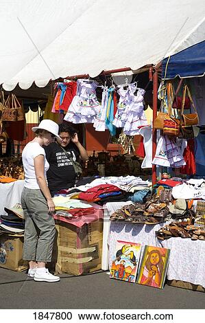 Stock Image - Puerto Corinto, Chinandega, Nicaragua, Central America; Shopper In Outdoor Craft Market. Fotosearch