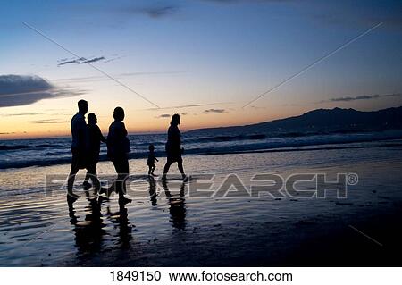 Stock Image - Puerto Vallarta, Mexico; People Walking Along Seashore At Sunset. Fotosearch