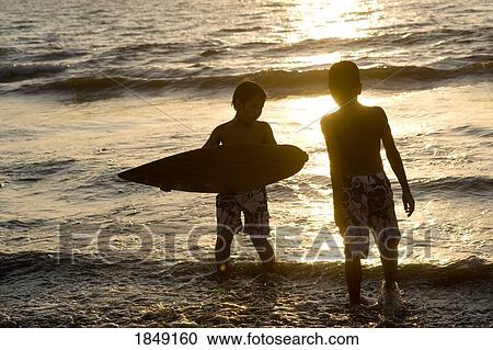 Stock Image - Puerto Vallarta, Mexico; Silhouette Of Two Boys At Seashore. Fotosearch