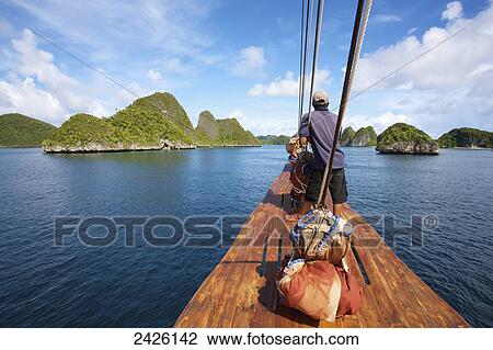 Pulau Wayag Islands with Tiger Blue Phinisi Schooner sailing through Raja Ampat; Indonesia View Large Photo Image Stock Image - Pulau Wayag Islands with Tiger Blue Phinisi Schooner sailing through Raja Ampat; Indonesia. Fotosearch