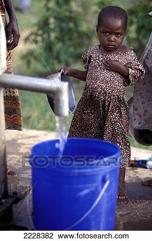Stock Image - Pumping Water Fron A New Well With Young Child In The Background, Nr Mwanza, Tanzania. Fotosearch