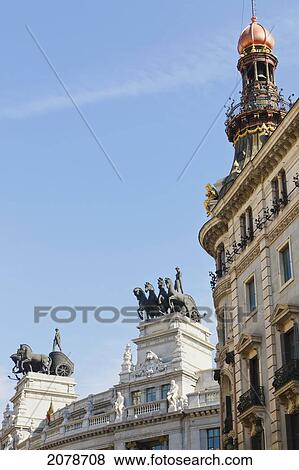 Quadrigas On Roof Of Banco De Bilbao Building (Statue Of Four Horses Drawing A Two-Wheeled Chariot) Building On Right Is Palacio De La Equitativa; Madrid Spain View Large Photo Image Stock Photo - Quadrigas On Roof Of Banco De Bilbao Building (Statue Of Four Horses Drawing A Two-Wheeled Chariot) Building On Right Is Palacio De La Equitativa; Madrid Spain. Fotosearch
