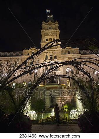 Stock Image - Quebec City's parliament building with water fountains illuminated at nighttime; Quebec City, Quebec, Canada. Fotosearch