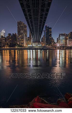 Stock Image - Queensboro Bridge and Manhattan skyline at sunset as viewed from Roosevelt Island; New York City, New York, United States of America. Fotosearch