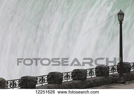 Railing and lamp post with the Horseshoe Falls in the background at Table Rock; Niagara Falls, Ontario, Canada View Large Photo Image Stock Photograph - Railing and lamp post with the Horseshoe Falls in the background at Table Rock; Niagara Falls, Ontario, Canada. Fotosearch