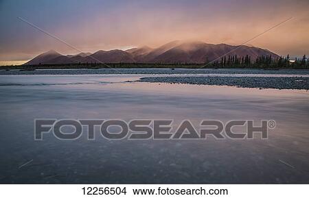 Picture - Rain and snow squalls race over the mountains during sunset on the Kelly River, in the western Brooks Range of Noatak National Preserve, Alaska, USA. Fotosearch