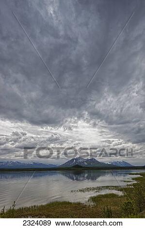 Stock Photo - Rain clouds gather above Dezadeash Lake, southern Yukon; Yukon, Canada. Fotosearch