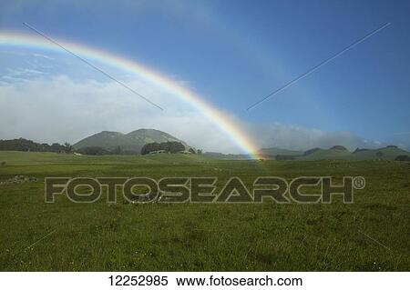 Stock Photography - Rainbow, cinder cones and ranch pasture; Island of Hawaii, Hawaii, United States of America. Fotosearch