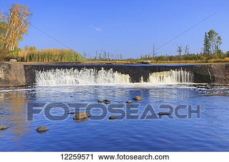 Stock Image - Rainbow Falls on the Whiteshell River in autumn, Whiteshell Provincial Park; Manitoba, Canada. Fotosearch