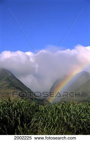 Stock Photography - Rainbow Over Mountain Tops, Blue Sky, Many Large White Clouds. Fotosearch
