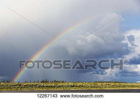 Stock Image - Rainbow over the Porcupine River in the Northern Yukon, near Old Crow; Yukon, Canada. Fotosearch