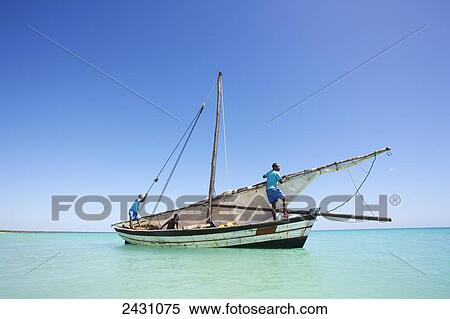 Stock Photography - Raising the sail on a boat on the Indian Ocean; Vamizi Island, Mozambique. Fotosearch