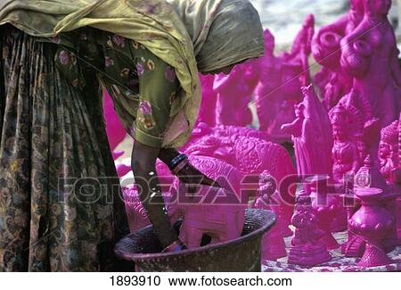 Stock Image - Rajasthani Woman Dying Clay Statues Before Painting Details. Fotosearch