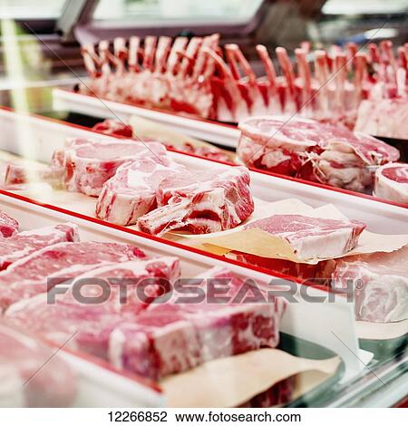 Stock Image - Raw meat counter at butcher shop; Ontario, Canada. Fotosearch