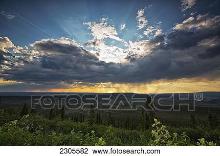 Rays Of Light Glow From Behind Gathering Storm Clouds Over Eagle Plains; Yukon Canada View Large Photo Image Stock Image - Rays Of Light Glow From Behind Gathering Storm Clouds Over Eagle Plains; Yukon Canada. Fotosearch