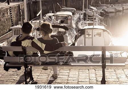 Rear View Of A Couple Relaxing By The Harbour At Saint Martin De Re; Poitou-Charentes, France View Large Photo Image Stock Photo - Rear View Of A Couple Relaxing By The Harbour At Saint Martin De Re; Poitou-Charentes, France. Fotosearch