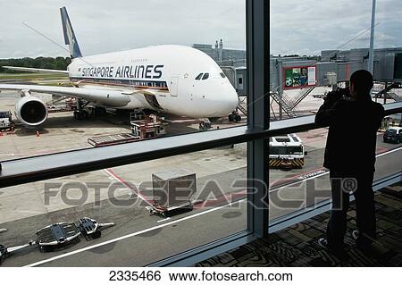 Stock Photograph - Rear View Of Man Standing In Airport; Singapore. Fotosearch
