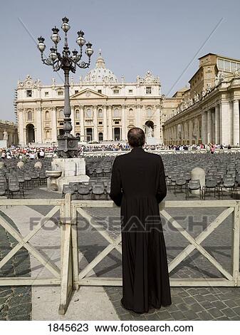 Stock Image - Rear View Of Priest Watching St. Peter's Square; Rome, Italy. Fotosearch