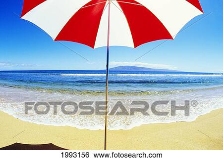 Stock Photograph - Red And White Umbrella On The Beach, Blue Sky And Ocean. Fotosearch
