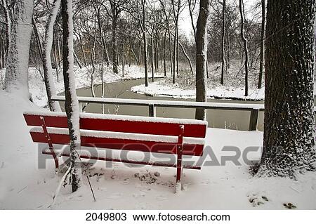 Stock Image - Red Bench And Heavy Snowfall, Kildonan Park, Winnipeg, Manitoba. Fotosearch