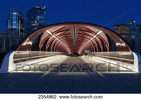 Stock Image - Red Bridge At Night With Lights And City Buildings In The Background; Calgary, Alberta, Canada. Fotosearch