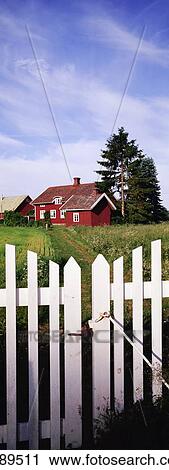 Stock Image - Red House And White Picket Fence. Fotosearch