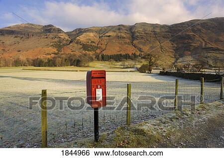 Stock Photograph - Red Mailbox On Roadside, Fields In Background; Cumbria, England, Uk. Fotosearch