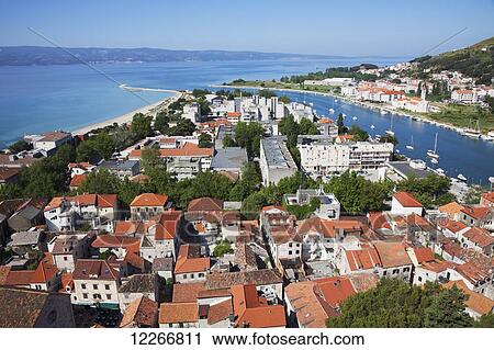 Stock Image - Red rooftops and view of the Dalmatian Coast; Omis, Split-Dalmatia, Croatia. Fotosearch