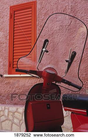 Stock Image - Red Scooter Against A Pink Wall, Close Up. Fotosearch