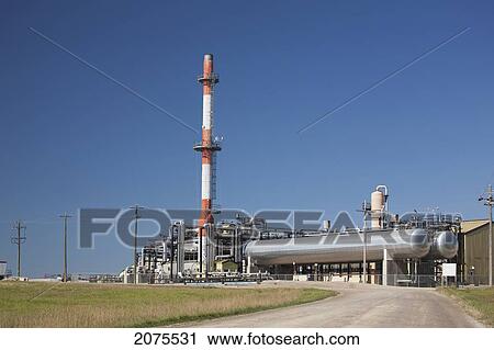Stock Image - Red Stripped Tower Of A Refinery And Stainless Steel Tanks With Blue Sky; Alberta Canada. Fotosearch
