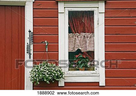 Stock Image - Red Wooden House With Plants In And By Window, Close Up. Fotosearch