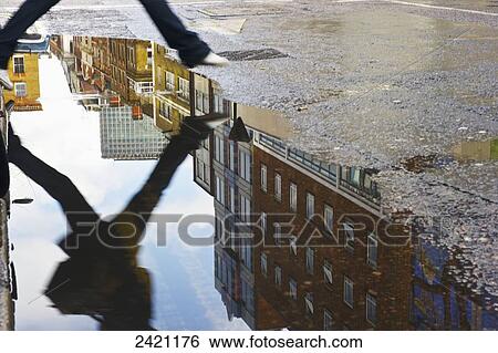 Reflection of a person jumping over a puddle after the rain, Soho; London, England View Large Photo Image Stock Photograph - Reflection of a person jumping over a puddle after the rain, Soho; London, England. Fotosearch