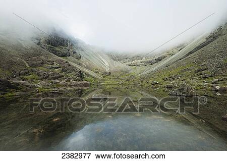 Reflections in perfectly still small lake below Sgurr Dearg and Sgurr Alasdair in the Black Cuillin; Isle of Skye, Scotland View Large Photo Image Stock Photo - Reflections in perfectly still small lake below Sgurr Dearg and Sgurr Alasdair in the Black Cuillin; Isle of Skye, Scotland. Fotosearch