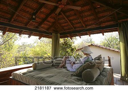 Relaxed and reading at Baghvan Wilderness Lodge, Pench National Park; Madhya Pradesh, India View Large Photo Image Stock Photo - Relaxed and reading at Baghvan Wilderness Lodge, Pench National Park; Madhya Pradesh, India. Fotosearch