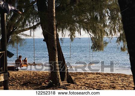 Stock Photo - Relaxing on a beach swing; Bamboo Island, Cambodia. Fotosearch