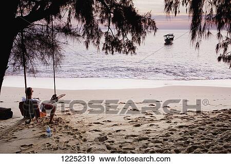Relaxing on a beach swing; Bamboo Island, Cambodia View Large Photo Image Stock Photo - Relaxing on a beach swing; Bamboo Island, Cambodia. Fotosearch