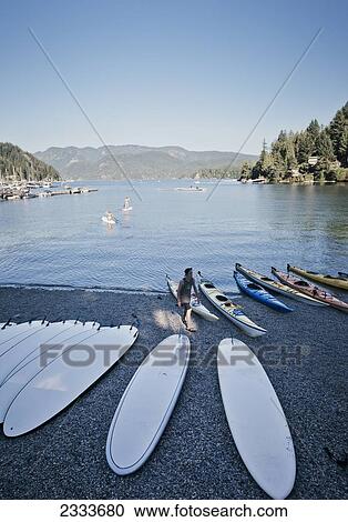 Stock Image - Rental Paddleboards And Kayaks On Shore Of Bay; Deep Cove Vancouver British Columbia. Fotosearch