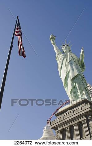 Stock Image - Replica Of The Statue Of Liberty With The American Flag On A Flagpole; Las Vegas Nevada Usa. Fotosearch