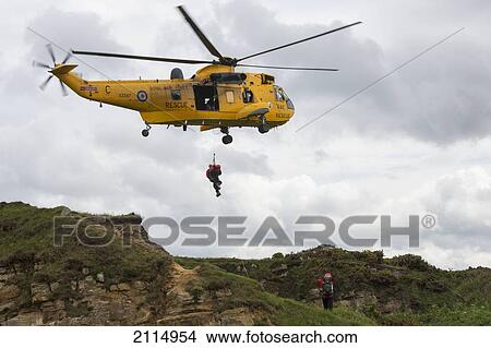Rescue Workers Hang From A Helicopter In Mid-Air; Northumberland England View Large Photo Image Picture - Rescue Workers Hang From A Helicopter In Mid-Air; Northumberland England. Fotosearch