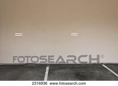 Stock Photograph - Reserved Parking Signs On Office Building Wall; Kelowna British Columbia Canada. Fotosearch