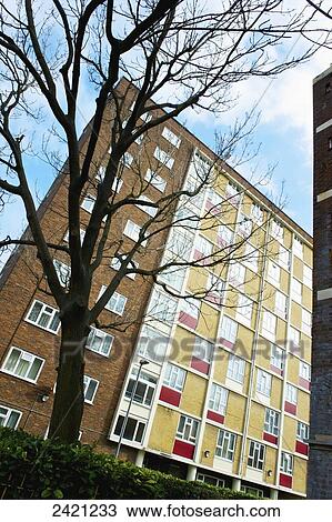 Stock Image - Residential building with brick, red and yellow panels on the facade, Shoreditch; London, England. Fotosearch